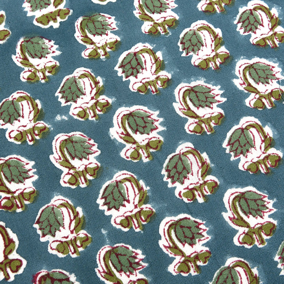 Pattern of green and red leaves on a blue background