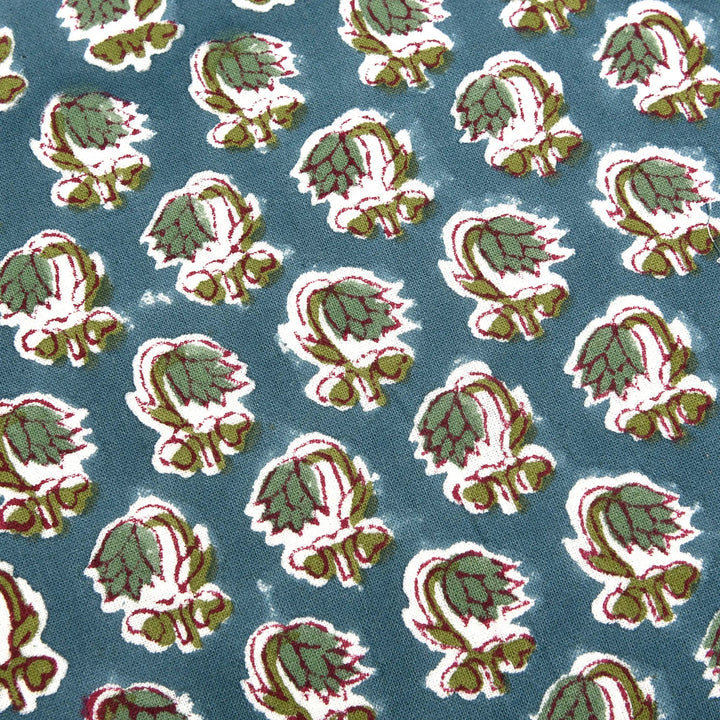 Pattern of green and red leaves on a blue background
