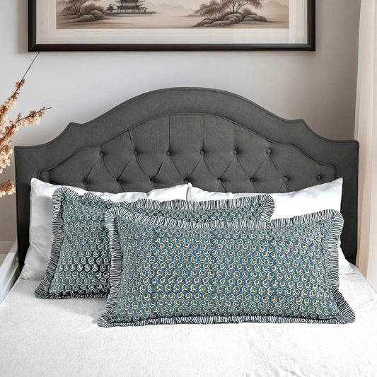 Large block print cotton pillows styled on gray upholstered bed.