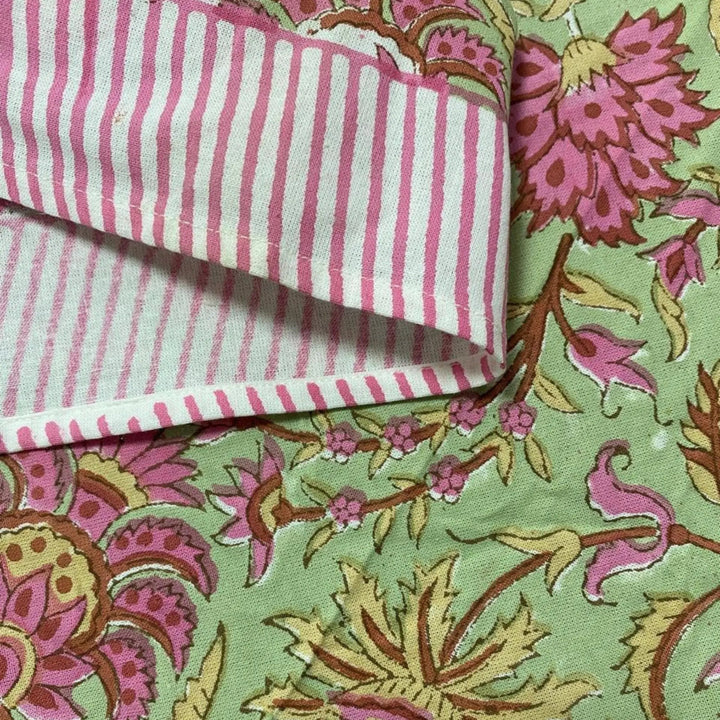 Close-up of pink and white striped fabric on a floral patterned background