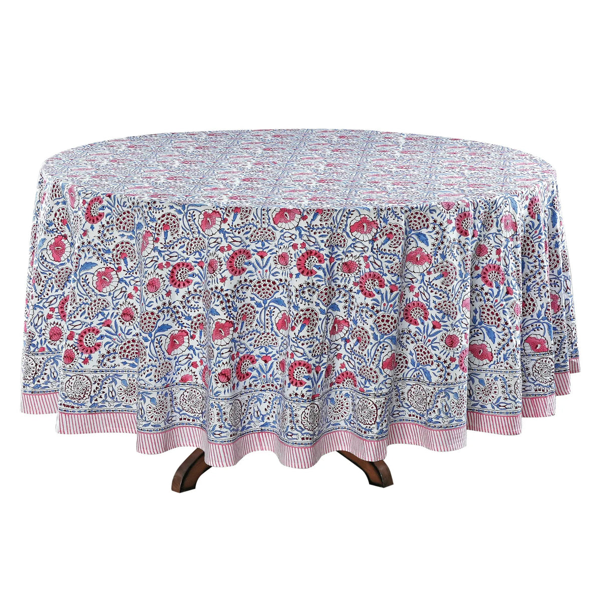Round floral-patterned tablecloth on a wooden table with a white background