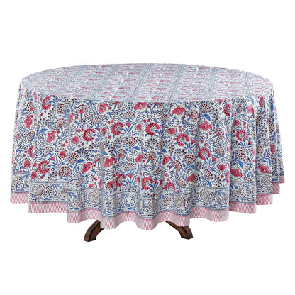 Round floral-patterned tablecloth on a wooden table with a white background