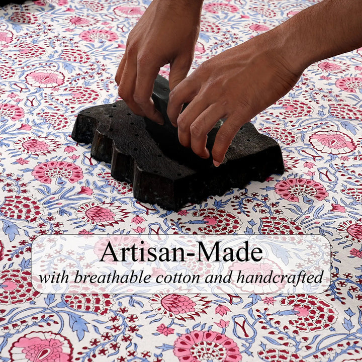 Hands working with black material on a floral fabric background, with text &