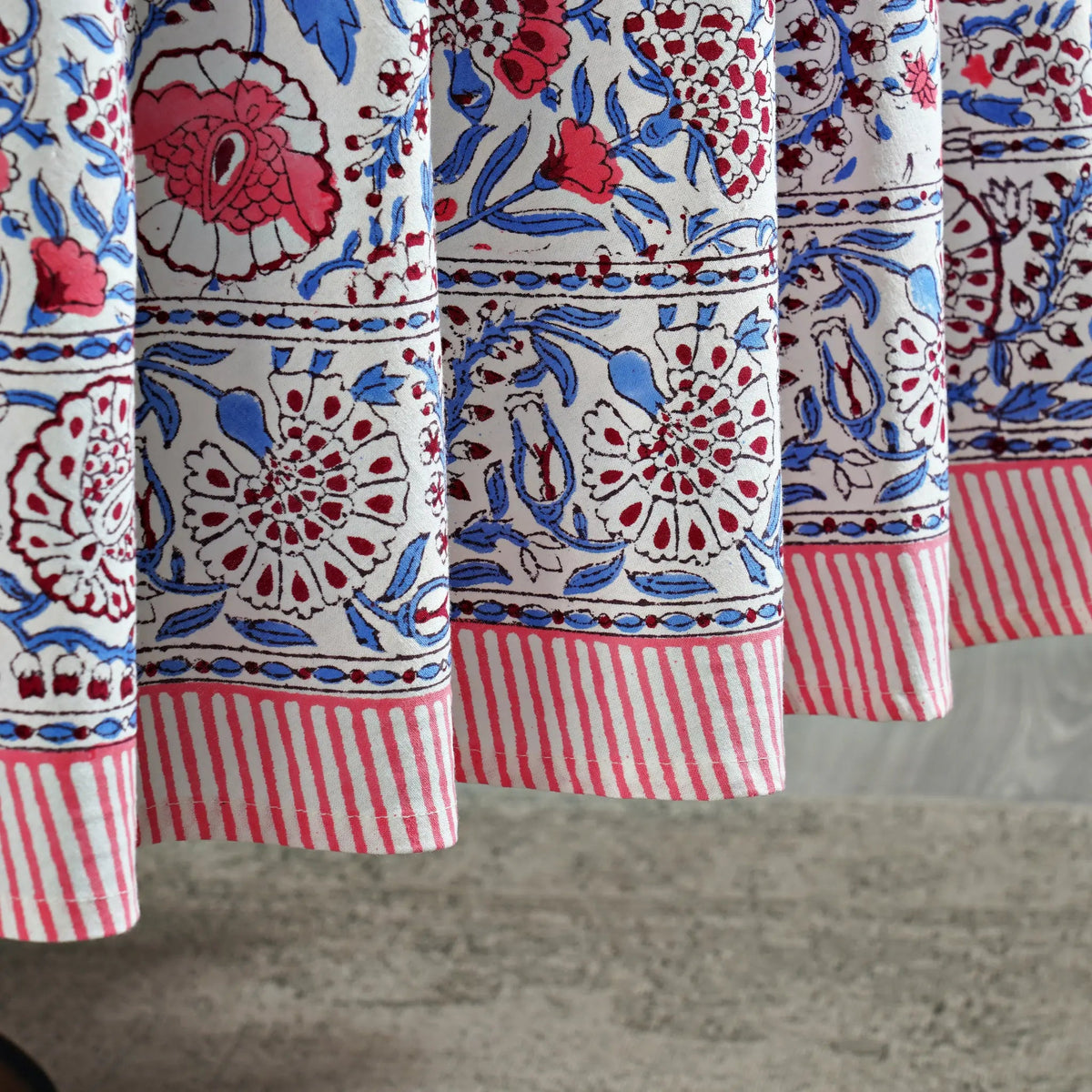 Close-up of a fabric with red, blue, and white patterns on a gray surface
