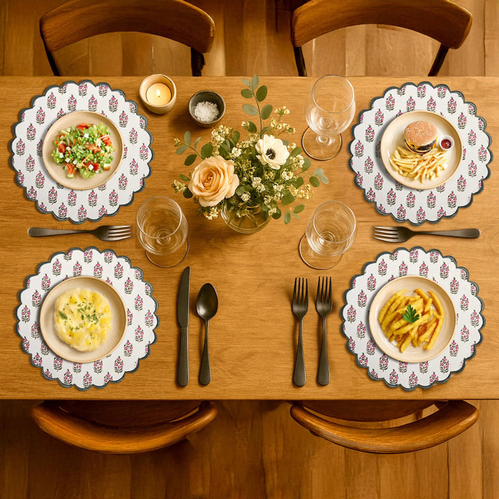 Dining table set with plates of food, glasses, and a vase of flowers.