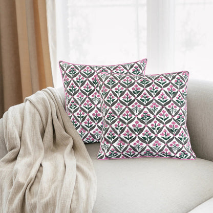 Decorative pillows with a pink and green pattern on a beige sofa.