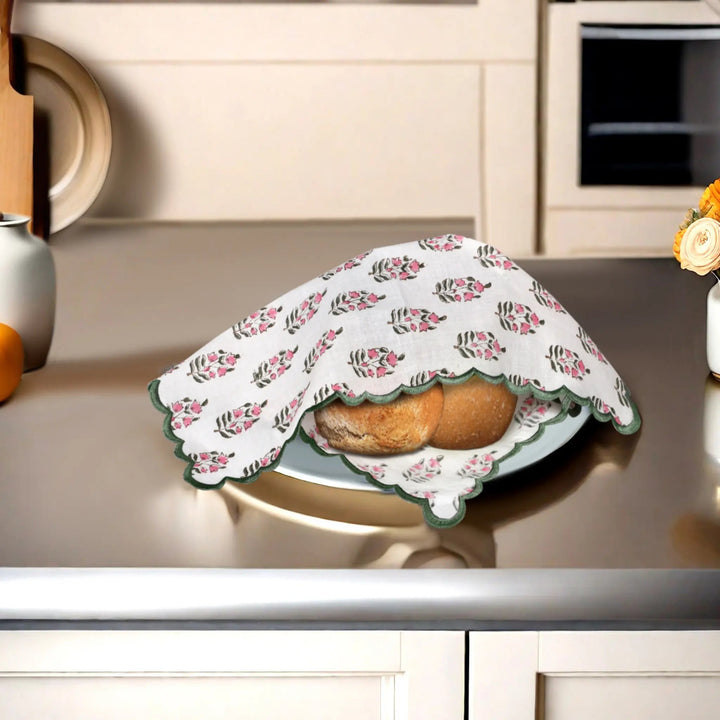 Floral-patterned cloth covering bread on a kitchen counter