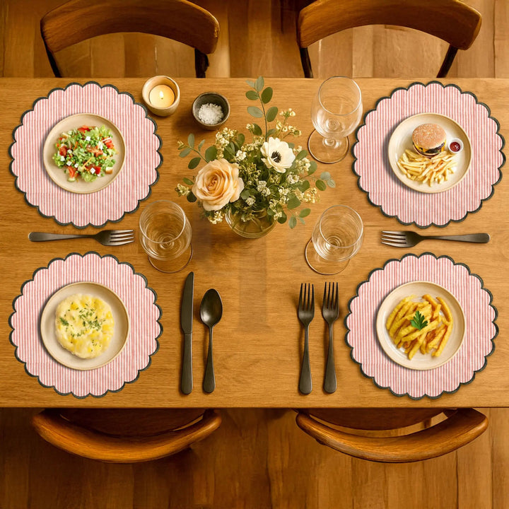 Dining table set with plates, glasses, cutlery, and a floral centerpiece.