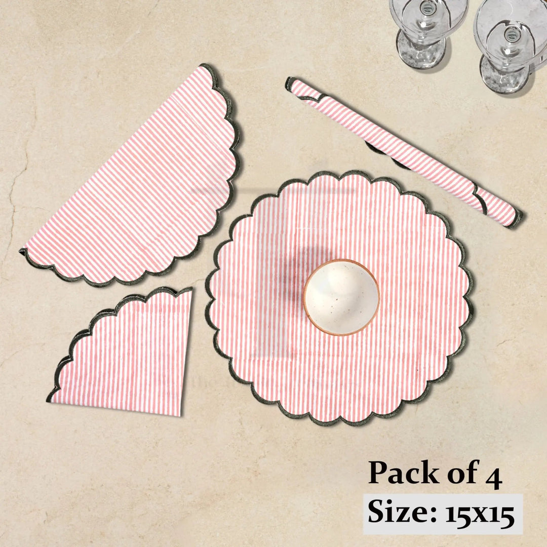 Pack of four pink and white patterned placemats on a beige surface.