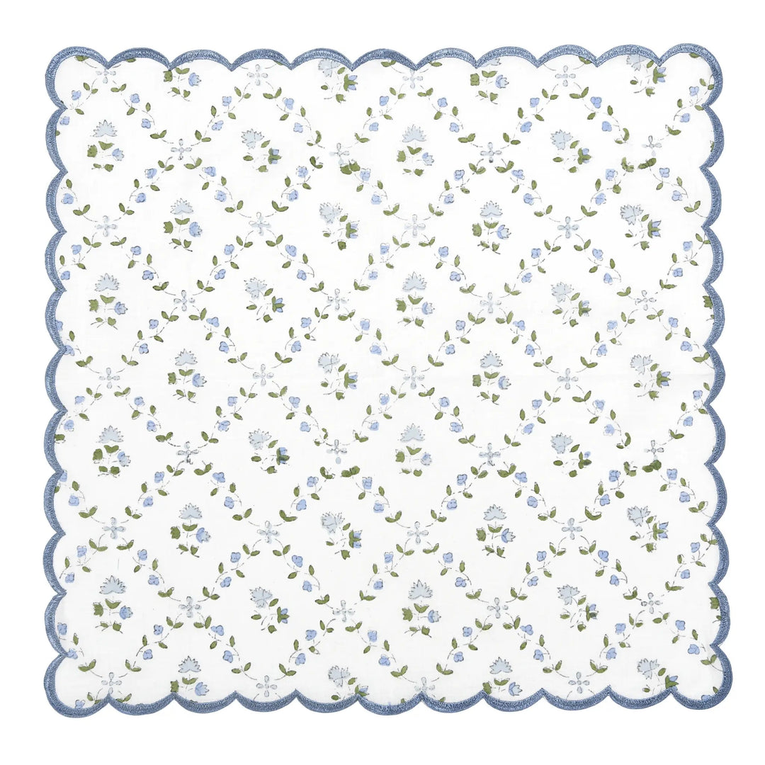 Floral patterned fabric swatch with scalloped edge on a white background