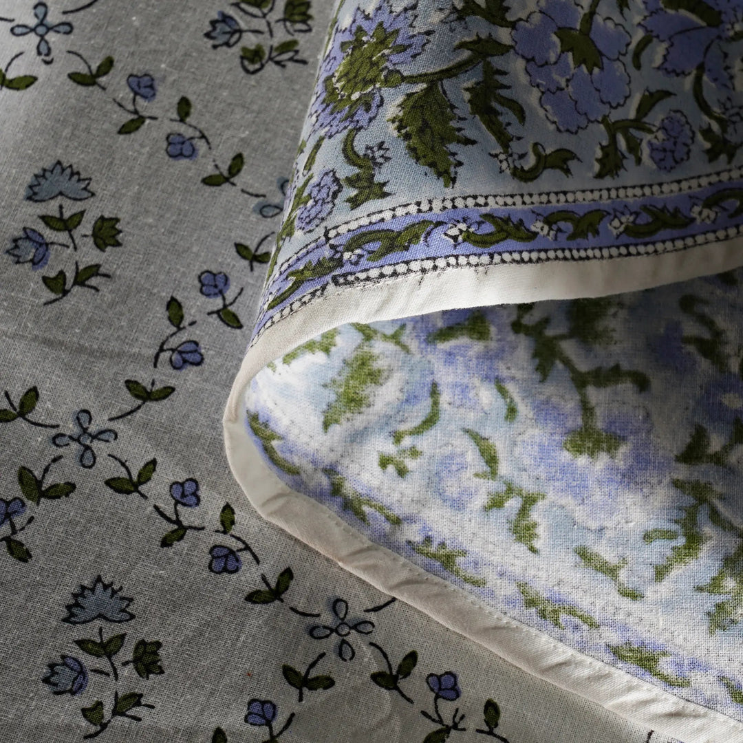 Floral patterned fabric with blue and green flowers on a gray background