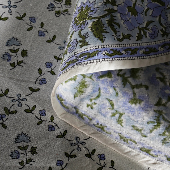 Floral patterned fabric with blue and green flowers on a gray background