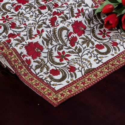 Decorative tablecloth with floral pattern and red flowers on a dark surface