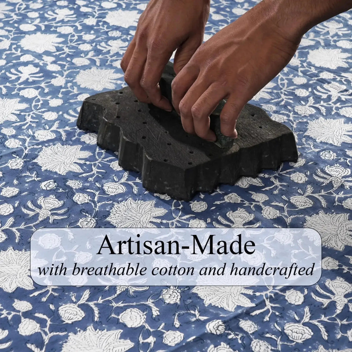 Hands pressing down on a black block with a floral patterned fabric in the background, featuring text 'Artisan-Made with breathable cotton and handcrafted'.