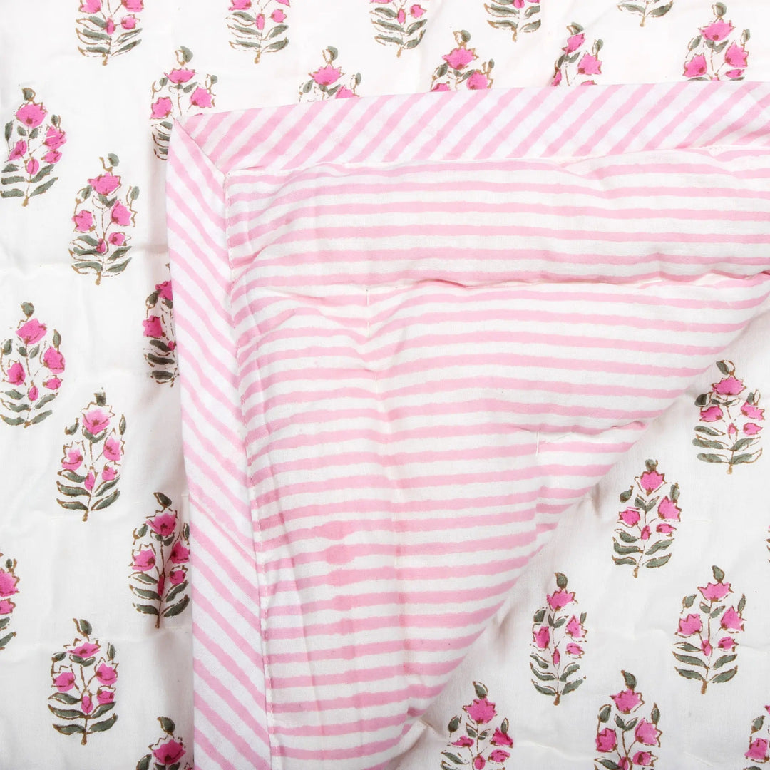 Pink and white striped fabric on a floral patterned background