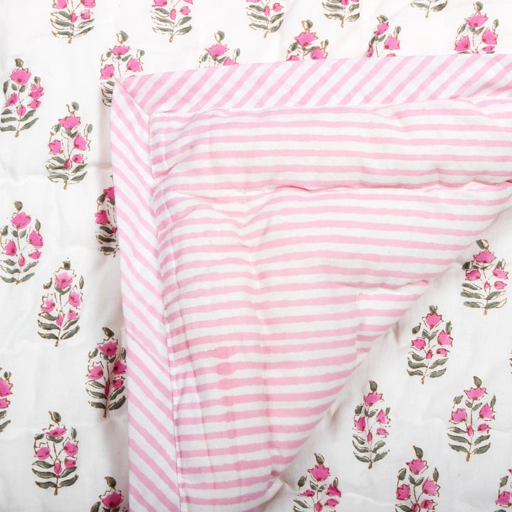 Pink and white striped fabric on a floral patterned background