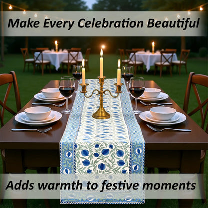 Dining table set for a celebration with a decorative table runner, candles, and wine glasses.