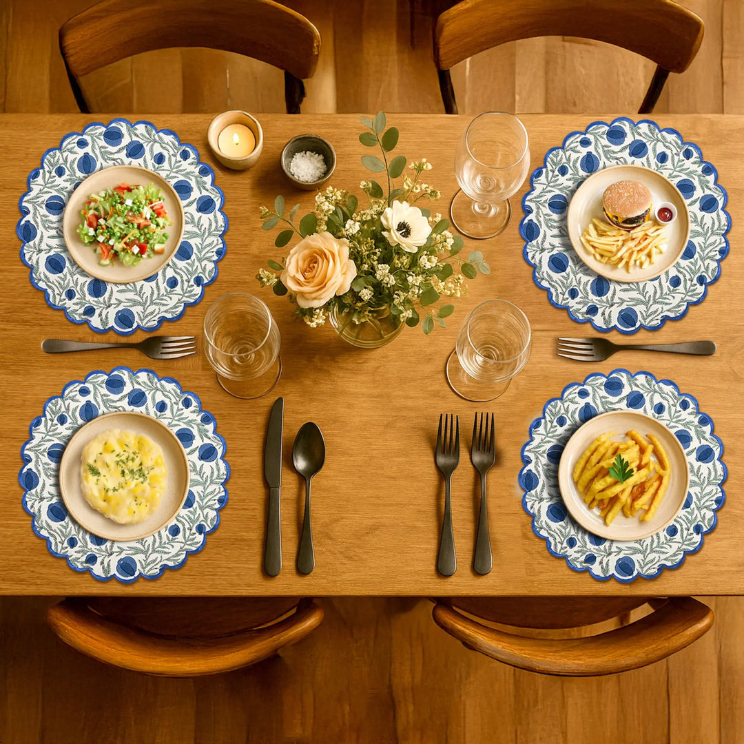 Dining table set with plates of food, glasses, and a floral centerpiece.