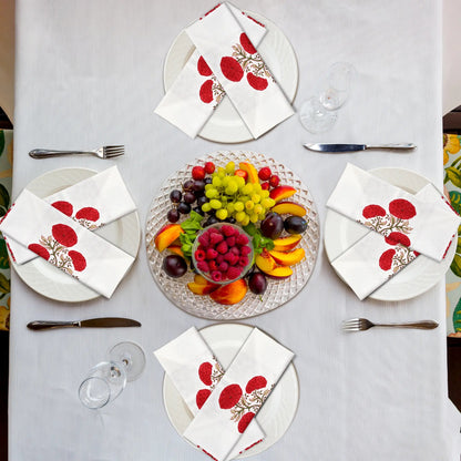 Elegant table setting with fruit platter and decorative napkins on a white tablecloth.