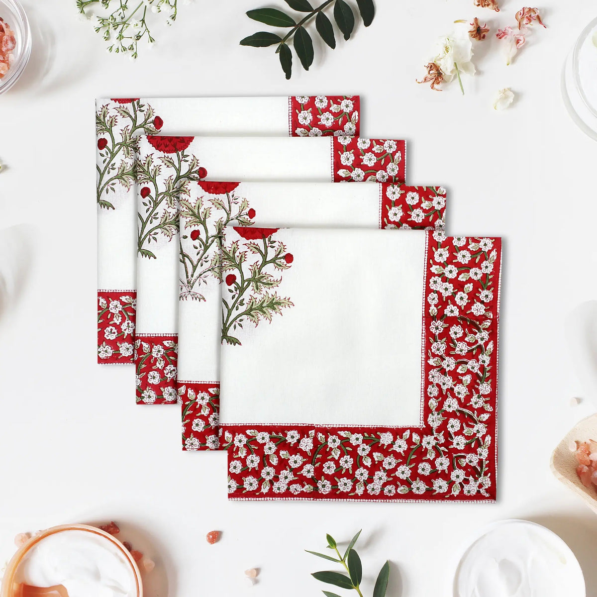 Set of red and white patterned placemats on a white surface with decorative elements.