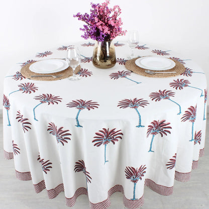 Tablecloth with palm tree design on a table set with plates, glasses, and cutlery.