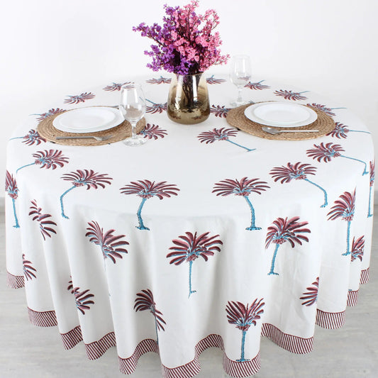 Tablecloth with palm tree design on a table set with plates, glasses, and cutlery.