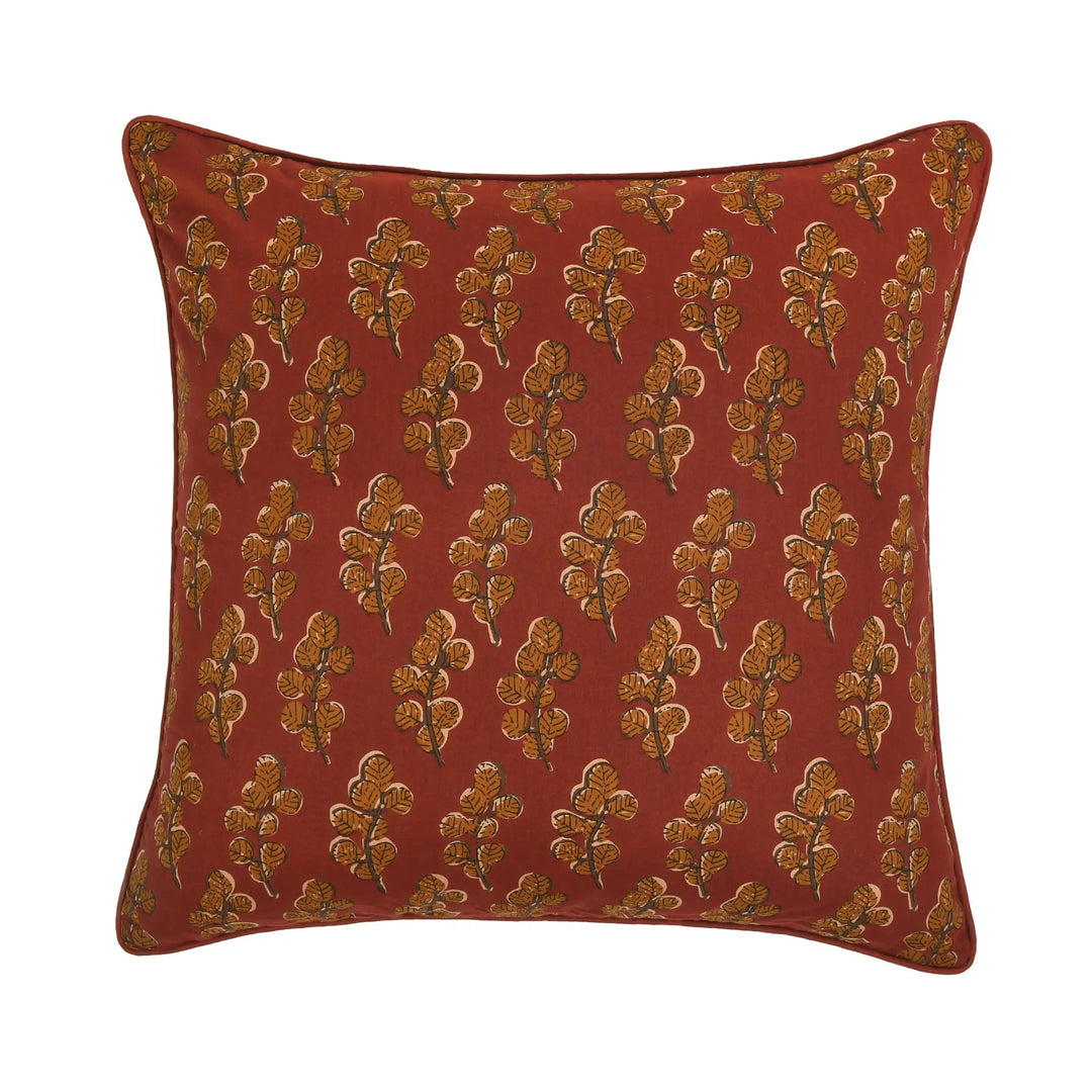 Red pillow with gold floral pattern on a white background