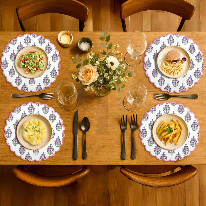 Dining table set with plates of food, glasses, and cutlery on a wooden table.