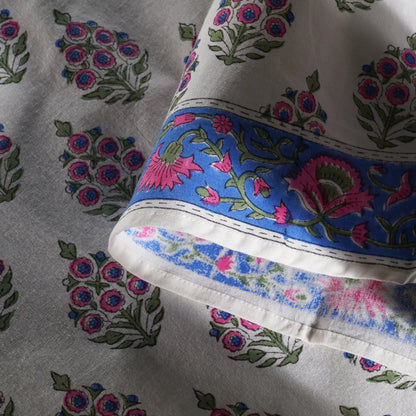 Close-up of fabric with floral patterns and a blue border.