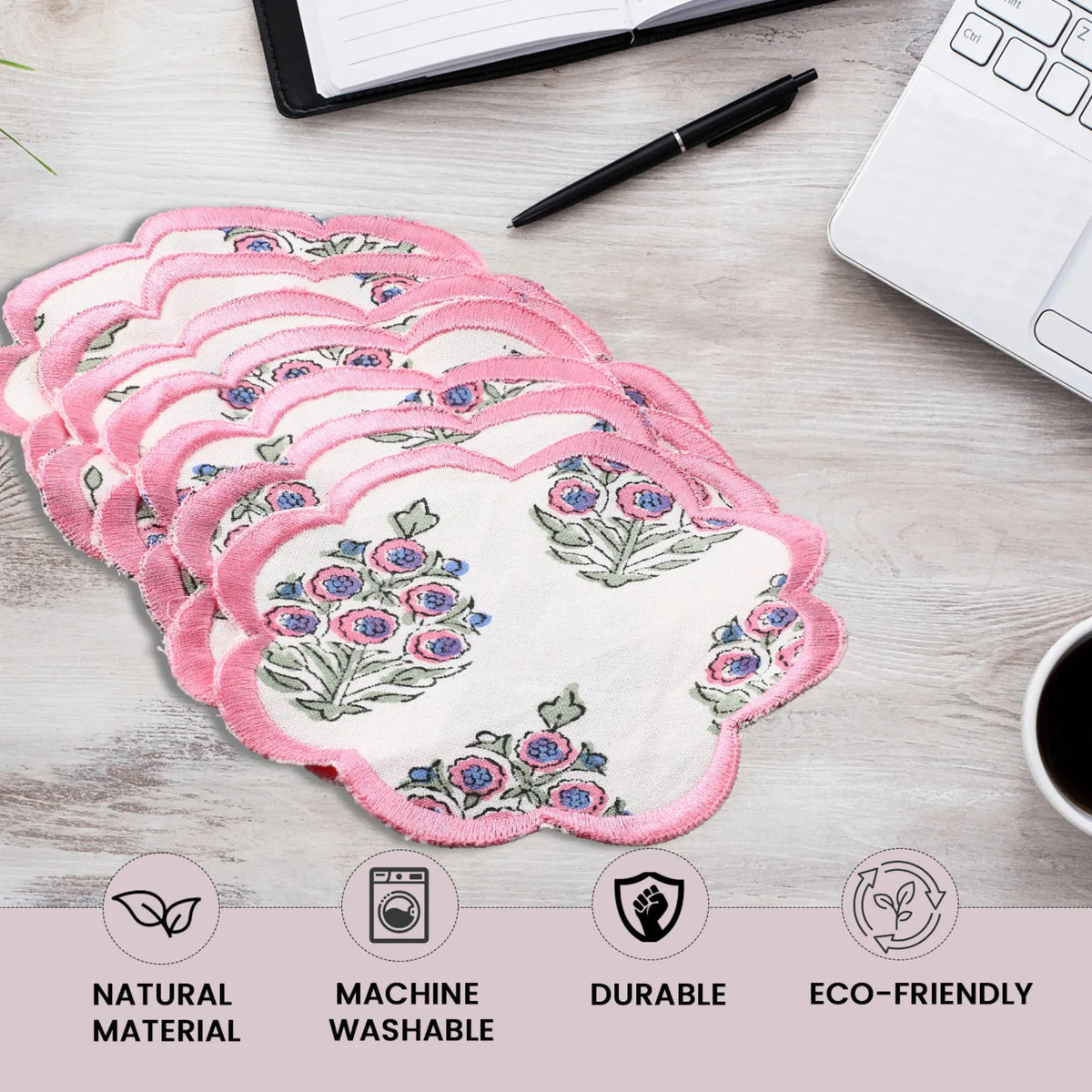 Set of floral pads on a desk with laptop, pen, and coffee cup.