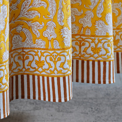 Close-up of patterned fabric with yellow, white, and brown colors.