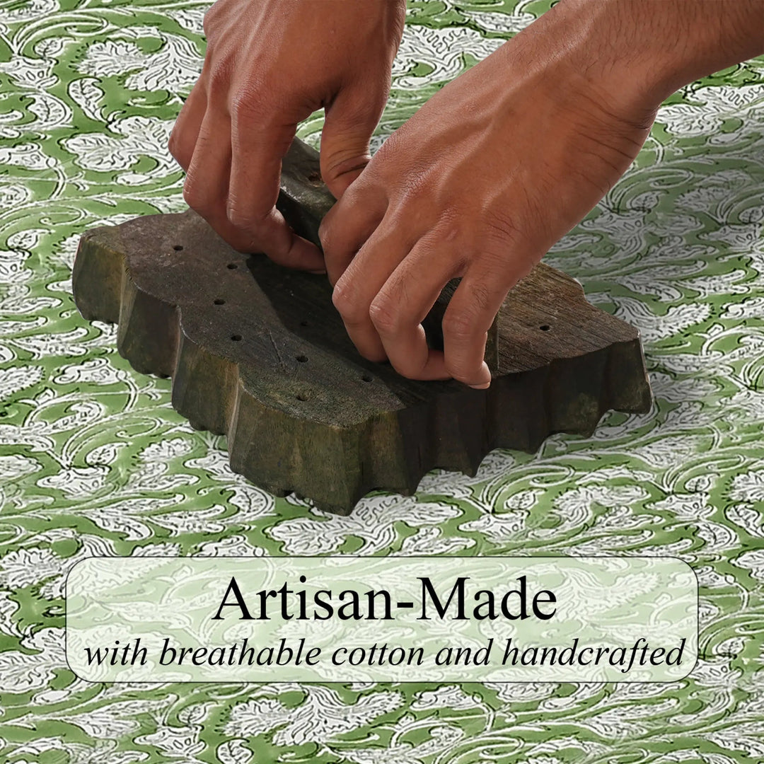 Hands using a wooden block printing tool on fabric with &