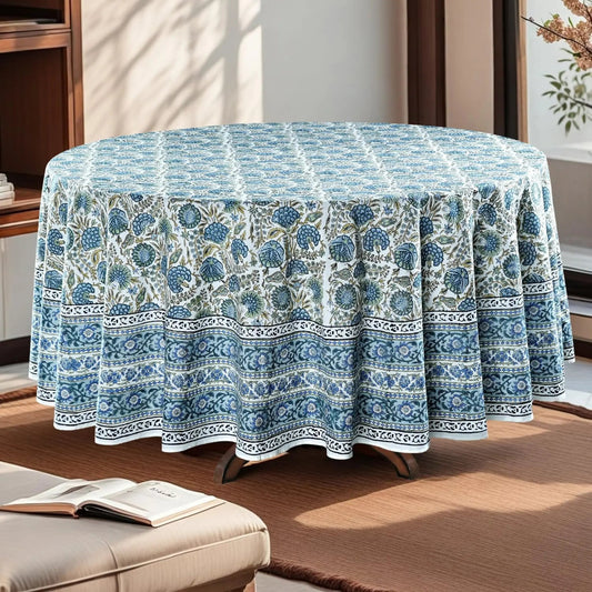 Round table covered with a blue floral patterned tablecloth in a room setting.