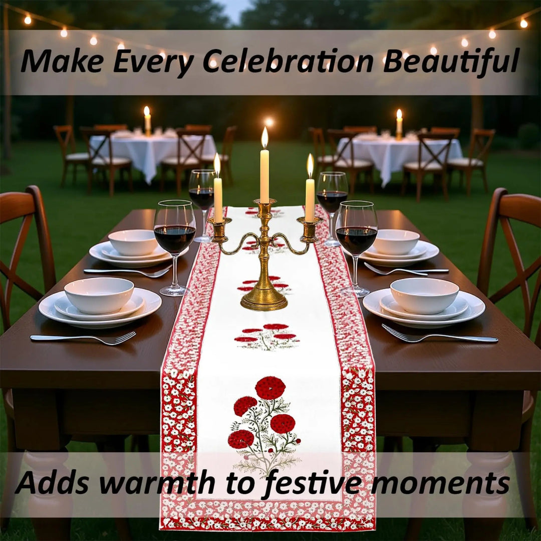 Dining table set with a floral table runner, candles, and wine glasses outdoors.