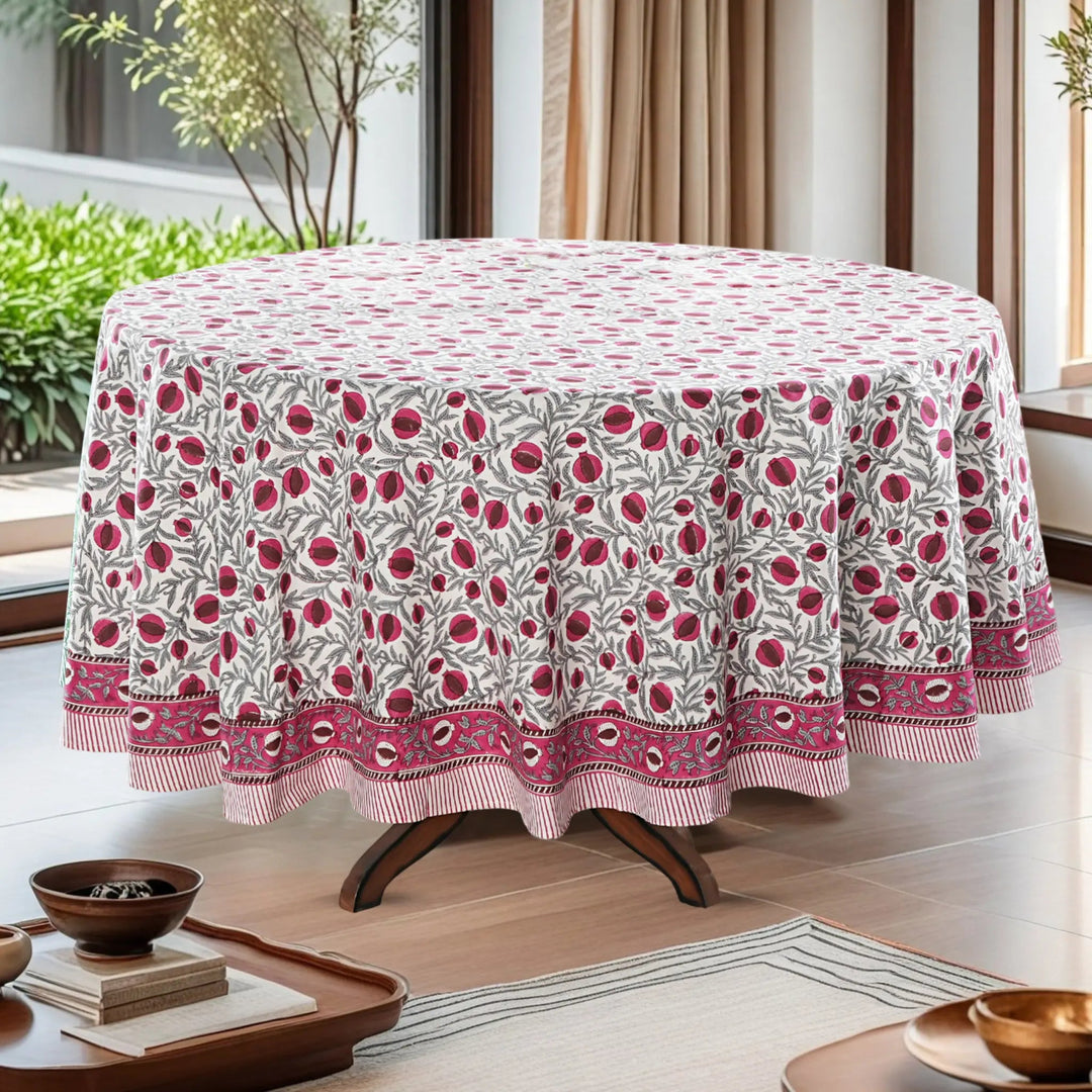 Round table with a floral patterned tablecloth in a bright room.