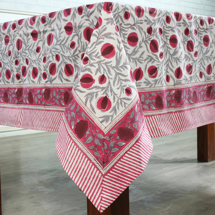 Decorative tablecloth with red and white pattern on a wooden table.