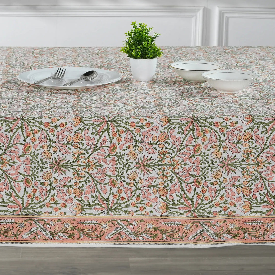 Table setting with a floral patterned tablecloth in a dining room.