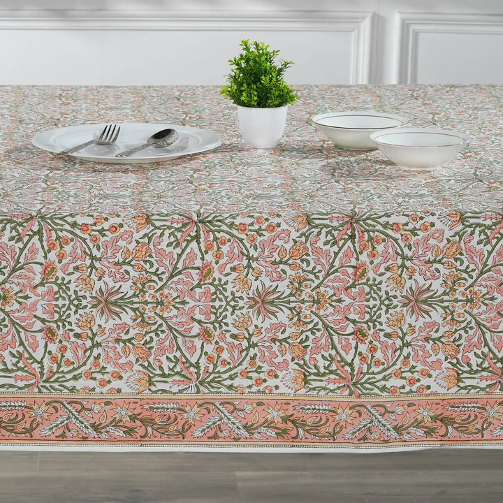 Table setting with a floral patterned tablecloth in a dining room.