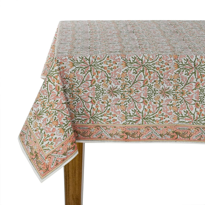Floral patterned tablecloth on a wooden table with a white background