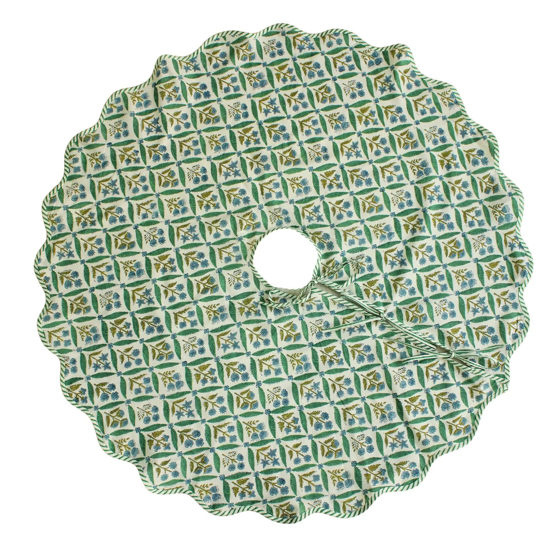Decorative green and blue patterned tree skirt on a white background