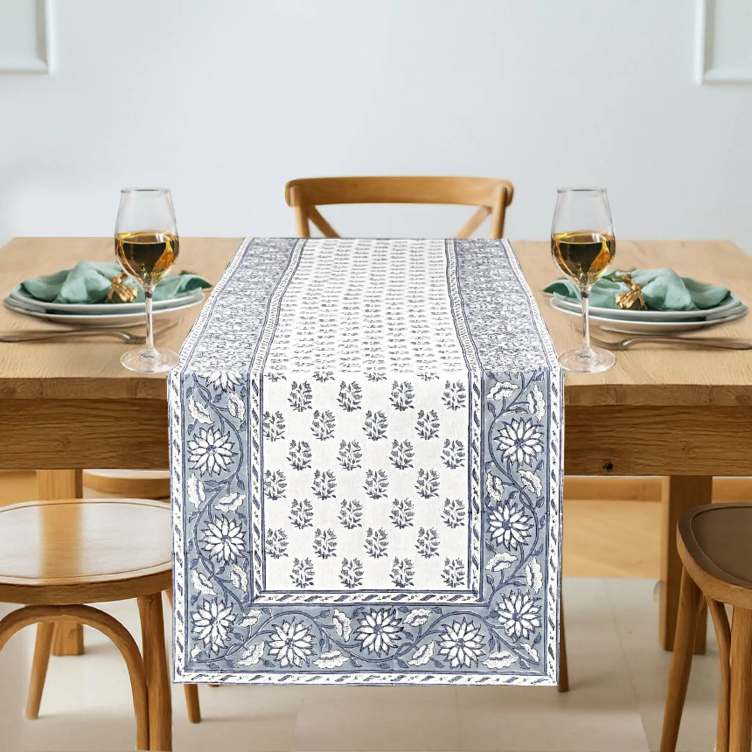 Table setting with a decorative table runner on a wooden table.