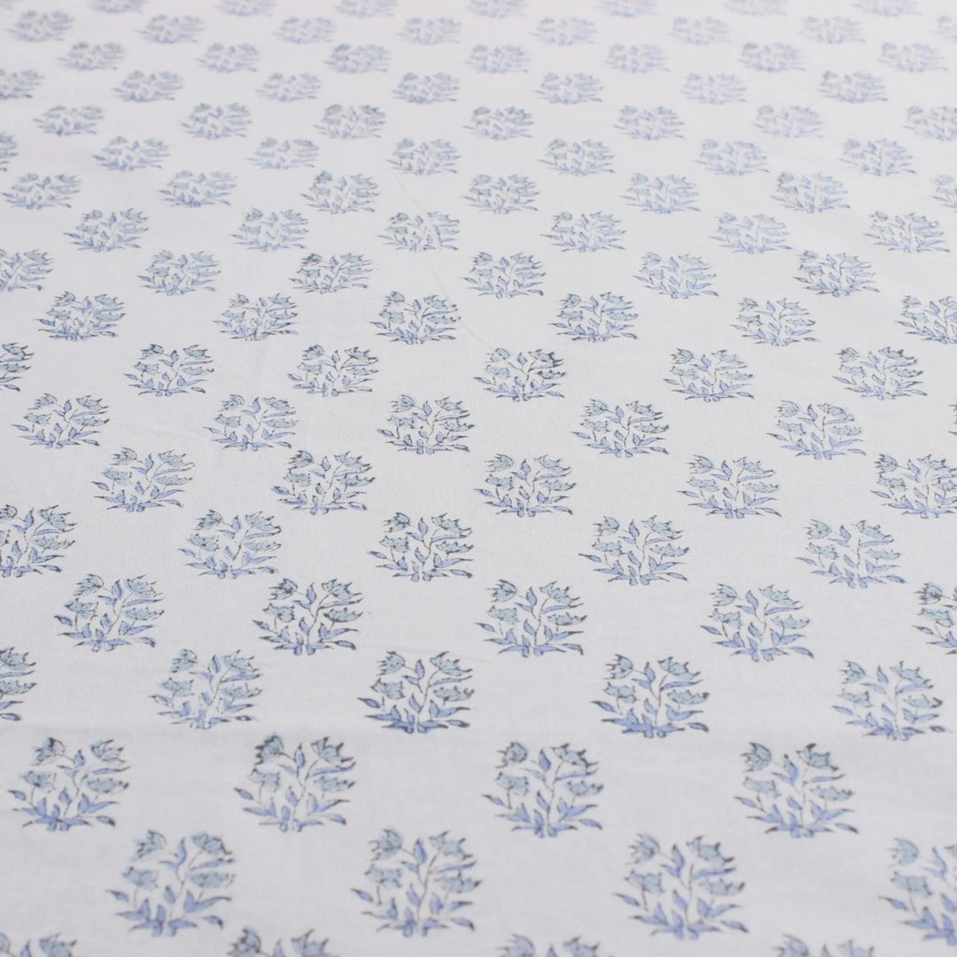 Patterned fabric with small blue floral designs on a light blue background