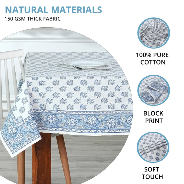 Tablecloth with blue floral pattern on a wooden table, featuring text about natural materials and fabric details.