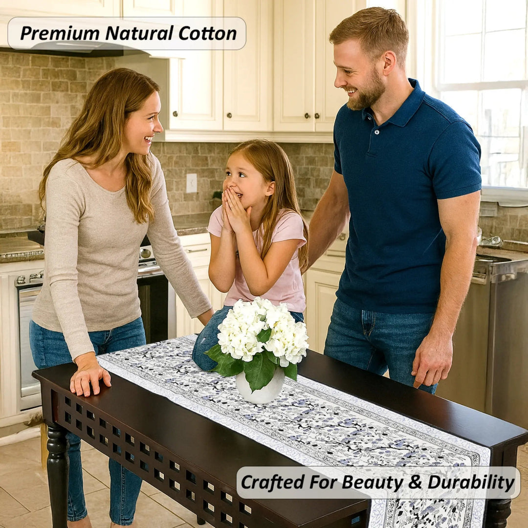 Family in a kitchen with a decorative table runner and flowers.