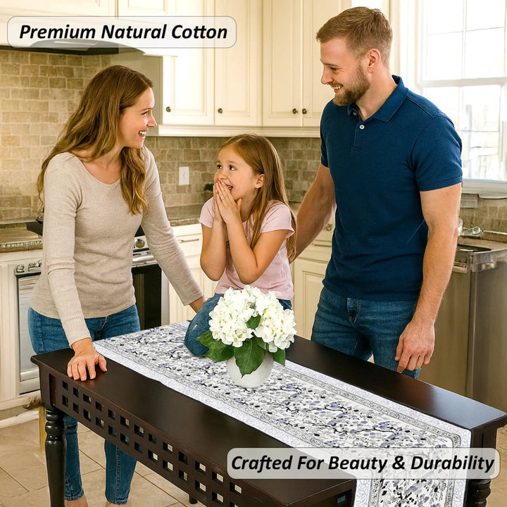 Family in a kitchen with a decorative table runner and flowers.