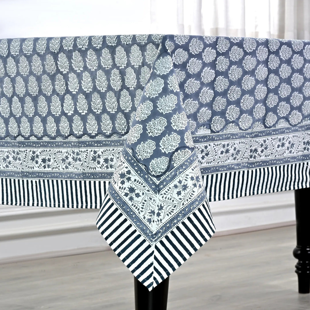 blue and white decorative cotton tablecloth with striped border on wooden table