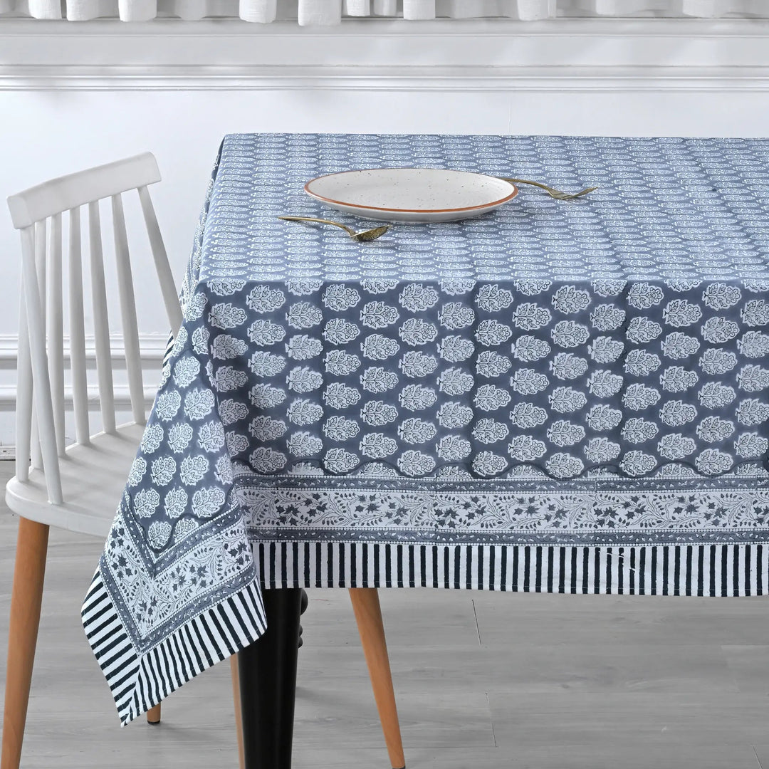 blue and white decorative cotton tablecloth with striped border on wooden table