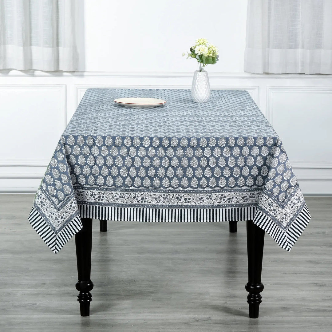 blue and white decorative cotton tablecloth with striped border on wooden table