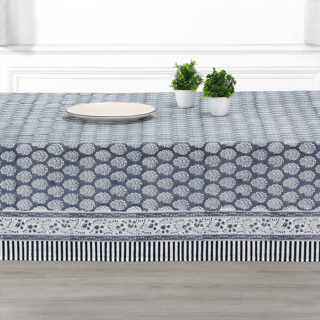 blue and white decorative cotton tablecloth with striped border on wooden table