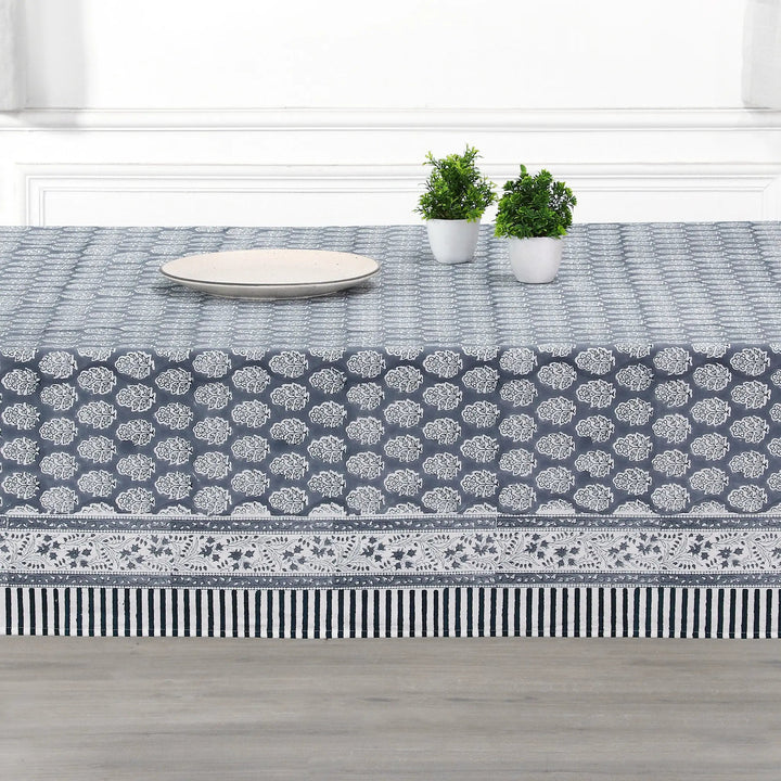 blue and white decorative cotton tablecloth with striped border on wooden table